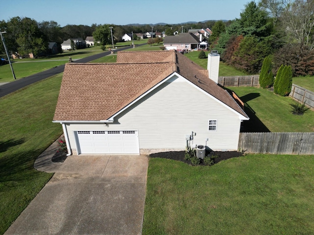 view of property exterior with a lawn and a garage