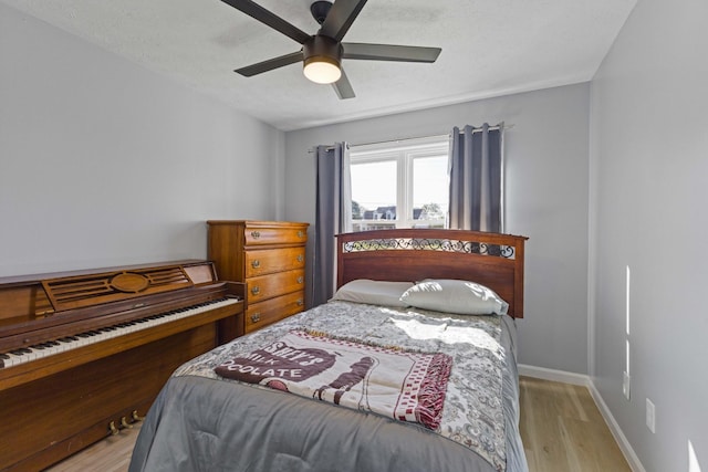 bedroom with ceiling fan, light hardwood / wood-style flooring, and a textured ceiling