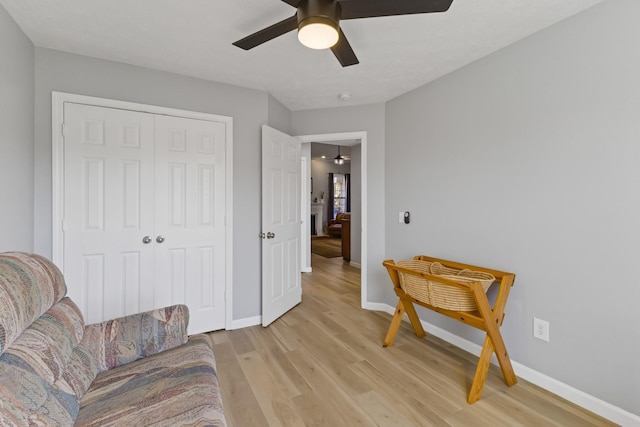 living area featuring light hardwood / wood-style floors and ceiling fan