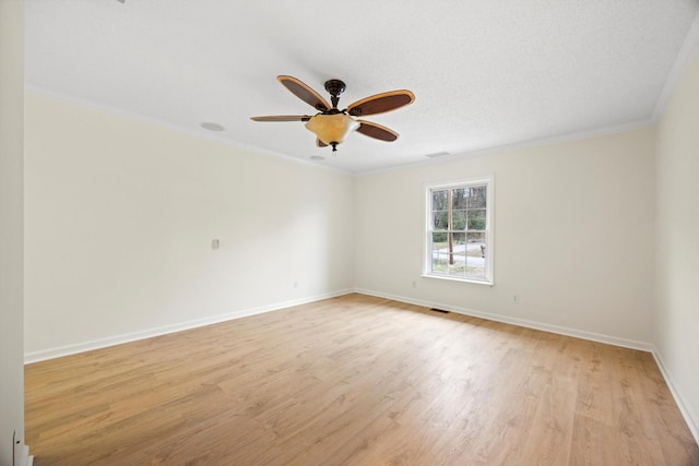 empty room featuring a textured ceiling, ceiling fan, light wood-type flooring, and crown molding