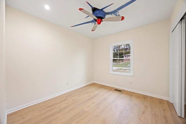 unfurnished bedroom with a closet, light hardwood / wood-style floors, and ceiling fan