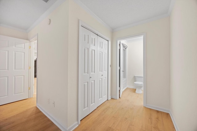 hall with a textured ceiling, light hardwood / wood-style flooring, and ornamental molding