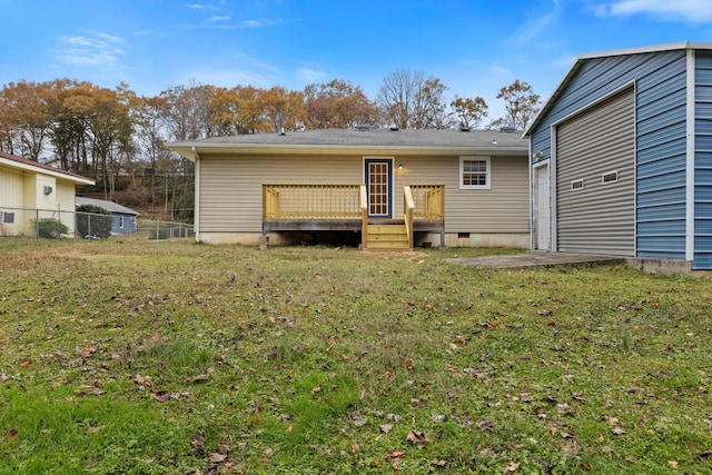 rear view of house with a lawn and a wooden deck