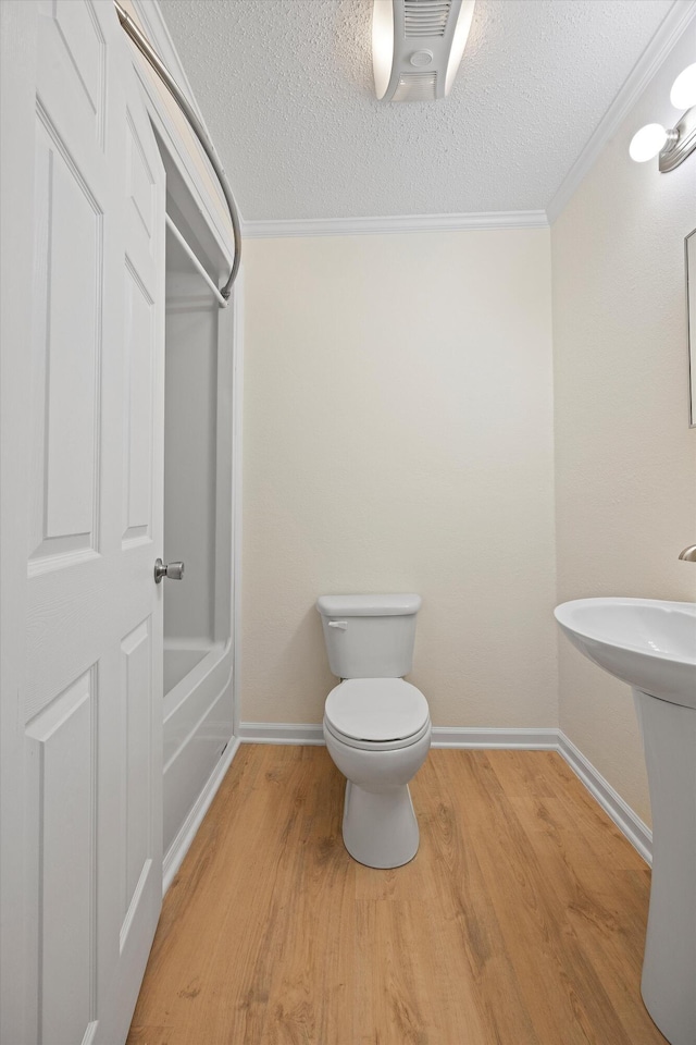 bathroom with hardwood / wood-style flooring, toilet, and ornamental molding