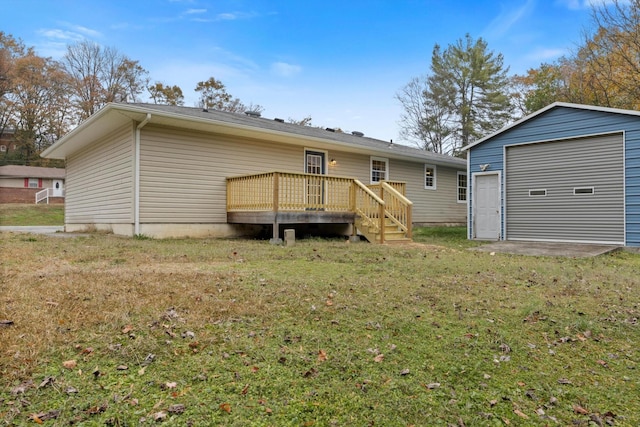 back of property with a garage, a yard, an outbuilding, and a wooden deck