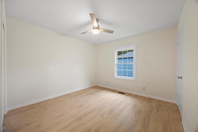 empty room with ceiling fan and light hardwood / wood-style flooring