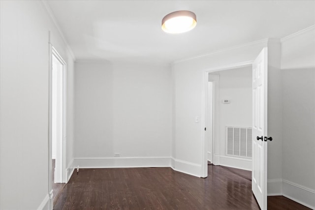 empty room with dark hardwood / wood-style flooring and ornamental molding