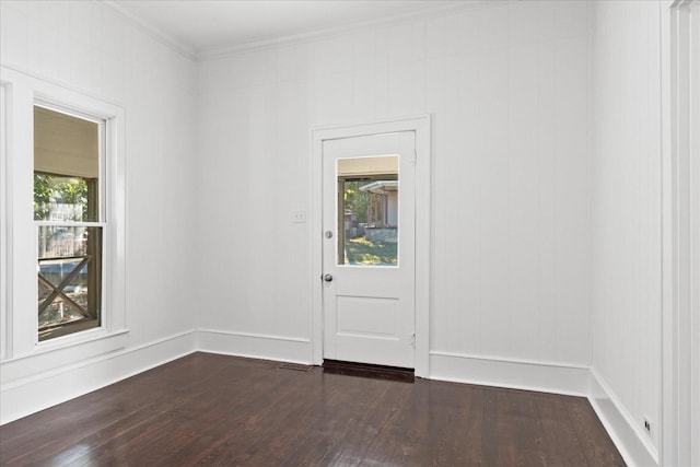 unfurnished room with crown molding, plenty of natural light, and dark wood-type flooring