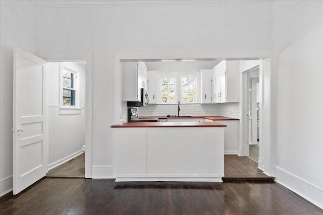 kitchen featuring appliances with stainless steel finishes, plenty of natural light, and dark wood-type flooring