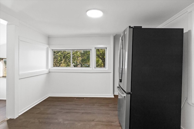 kitchen with dark hardwood / wood-style flooring, stainless steel refrigerator, and ornamental molding