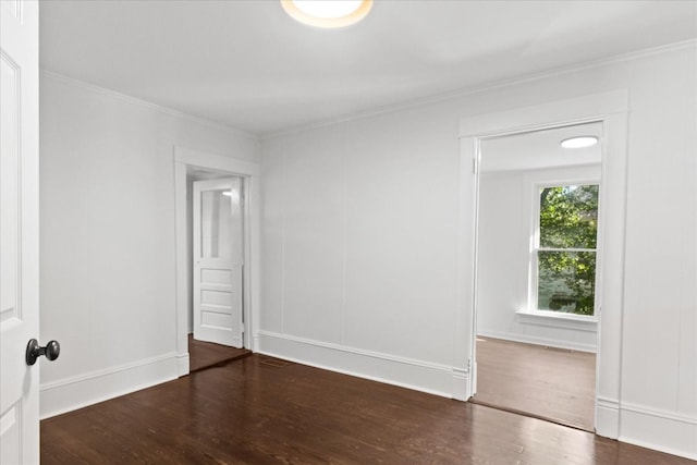 empty room featuring crown molding and dark hardwood / wood-style flooring