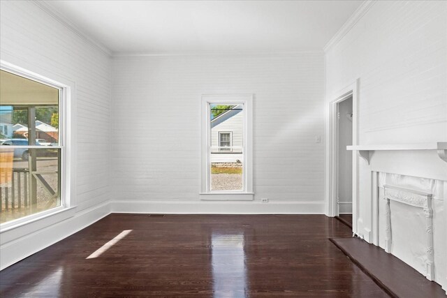 unfurnished living room featuring dark hardwood / wood-style flooring, ornamental molding, and a wealth of natural light