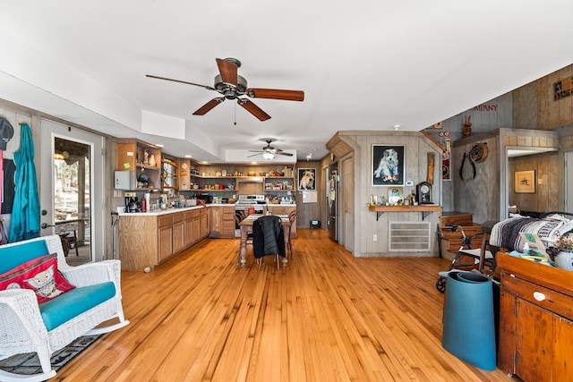 interior space featuring light hardwood / wood-style floors, stainless steel refrigerator, and wooden walls