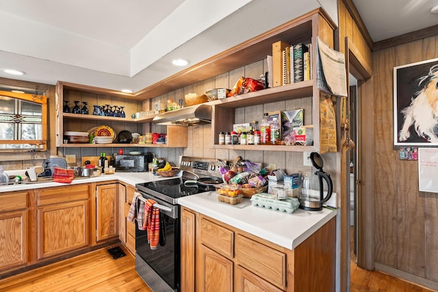 kitchen featuring stainless steel electric stove and light hardwood / wood-style floors