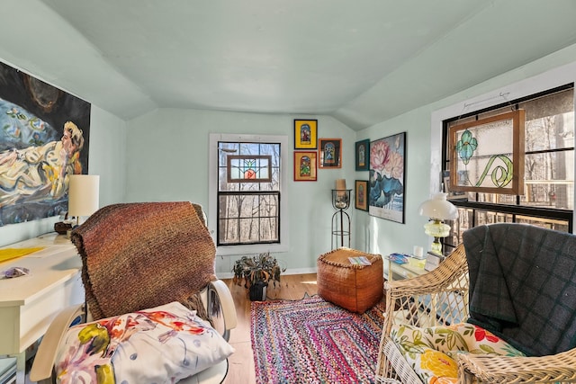 sitting room with hardwood / wood-style floors and vaulted ceiling