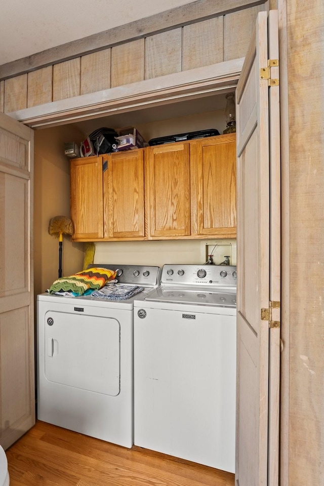 laundry area with cabinets, light wood-type flooring, and independent washer and dryer