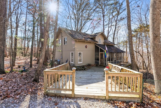 rear view of property with a deck and a sunroom