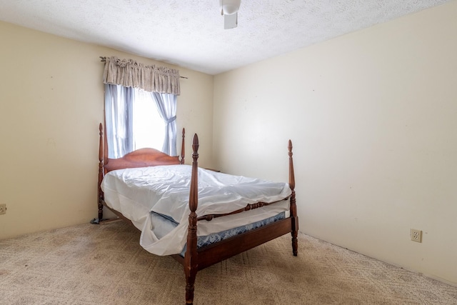 carpeted bedroom with ceiling fan and a textured ceiling