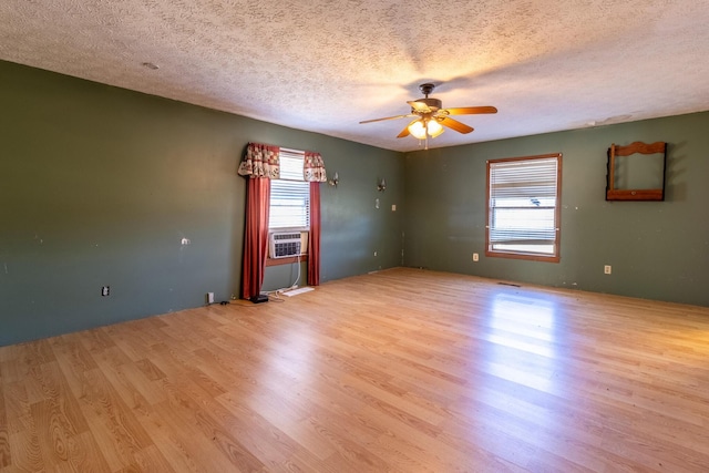 spare room with ceiling fan, a textured ceiling, a wealth of natural light, and light hardwood / wood-style flooring