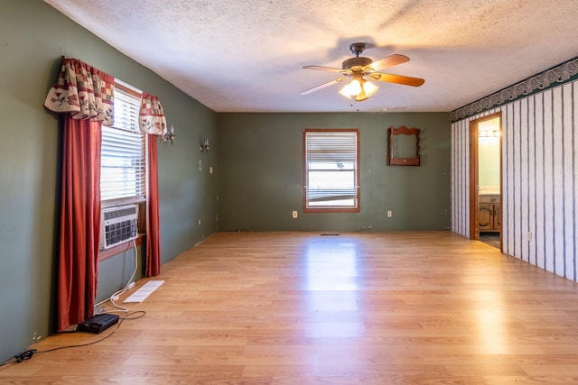 spare room with ceiling fan, light wood-type flooring, and a textured ceiling