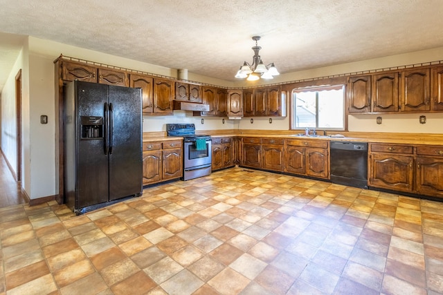 kitchen featuring a textured ceiling, an inviting chandelier, hanging light fixtures, and black appliances