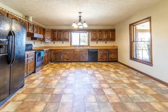 kitchen featuring sink, a notable chandelier, pendant lighting, a textured ceiling, and black appliances