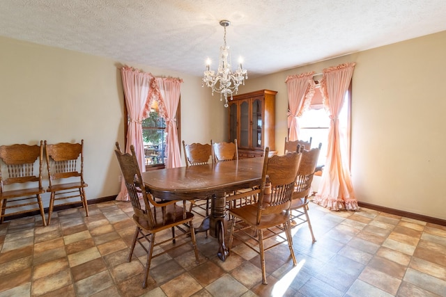 dining space with plenty of natural light, a textured ceiling, and a chandelier