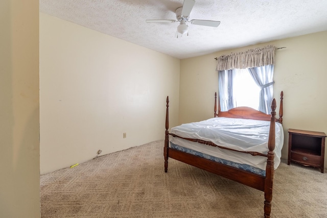 bedroom with ceiling fan, light colored carpet, and a textured ceiling