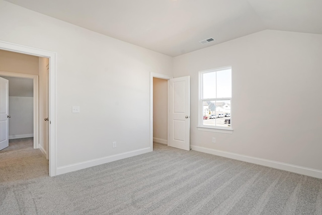 empty room featuring light carpet and lofted ceiling