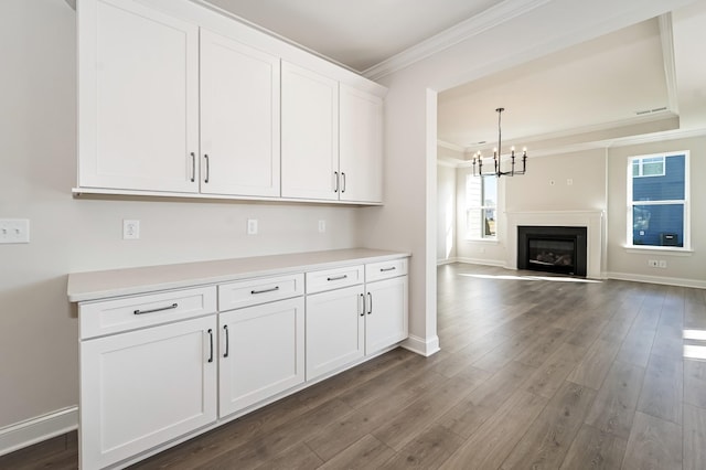 kitchen with white cabinetry, crown molding, dark hardwood / wood-style floors, and an inviting chandelier