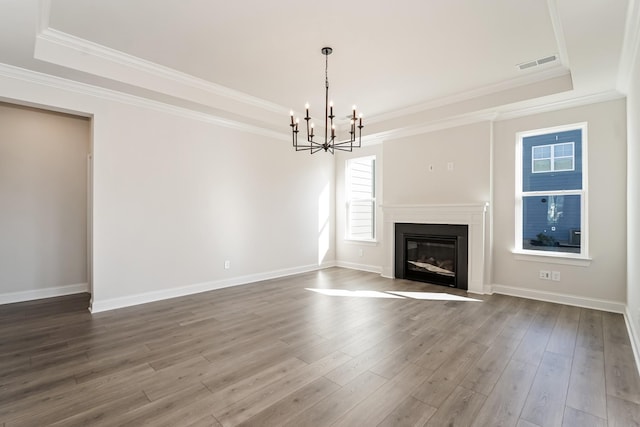 unfurnished living room featuring hardwood / wood-style floors, a chandelier, and a tray ceiling