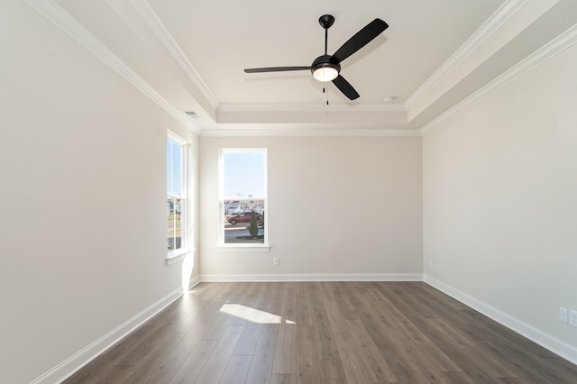 empty room with a tray ceiling, crown molding, ceiling fan, and dark hardwood / wood-style floors