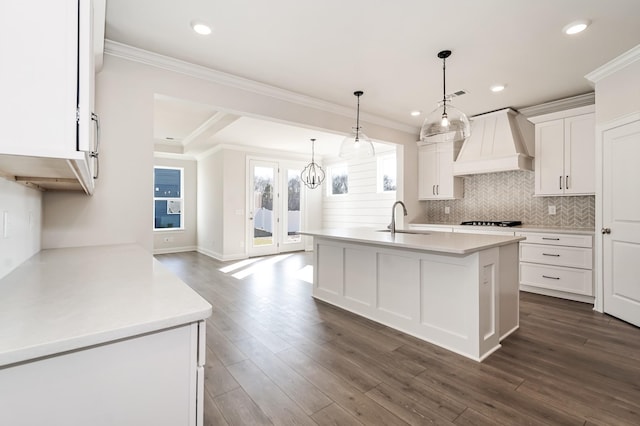 kitchen featuring white cabinets, custom range hood, crown molding, and dark wood-type flooring