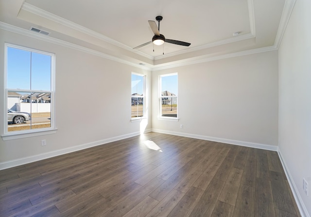 empty room with a tray ceiling, crown molding, ceiling fan, and dark hardwood / wood-style floors