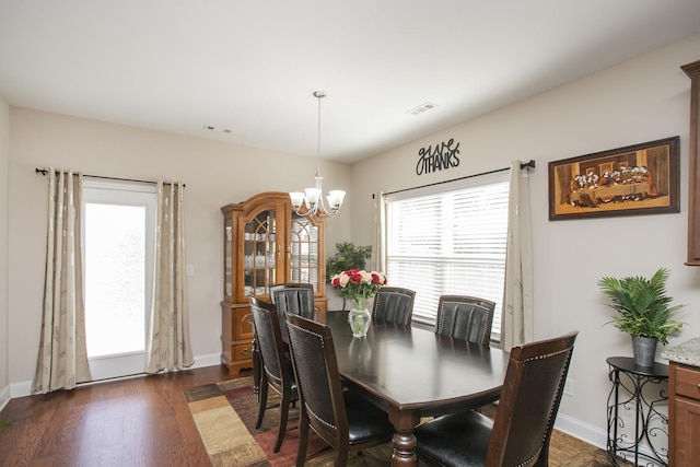 dining room with a notable chandelier and dark wood-type flooring