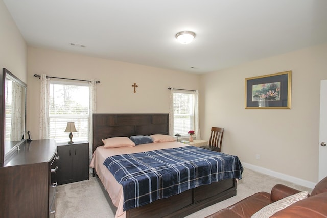 carpeted bedroom featuring multiple windows