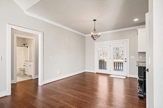 unfurnished living room featuring dark hardwood / wood-style flooring, a chandelier, and ornamental molding