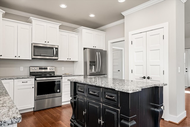 kitchen with a center island, white cabinets, crown molding, dark hardwood / wood-style floors, and stainless steel appliances