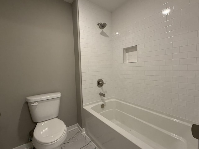 bathroom with tiled shower / bath combo and toilet