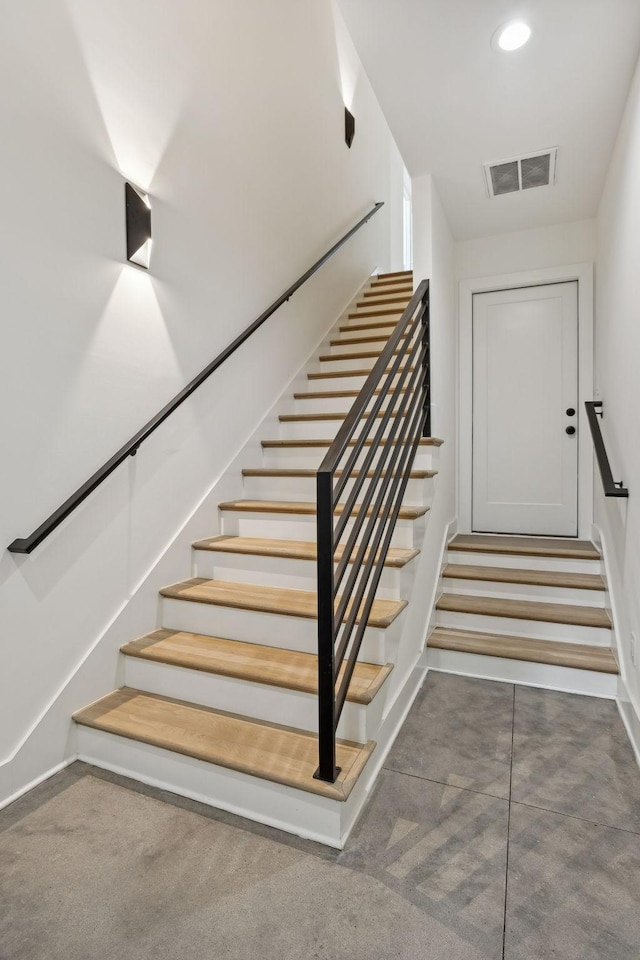 staircase featuring carpet flooring