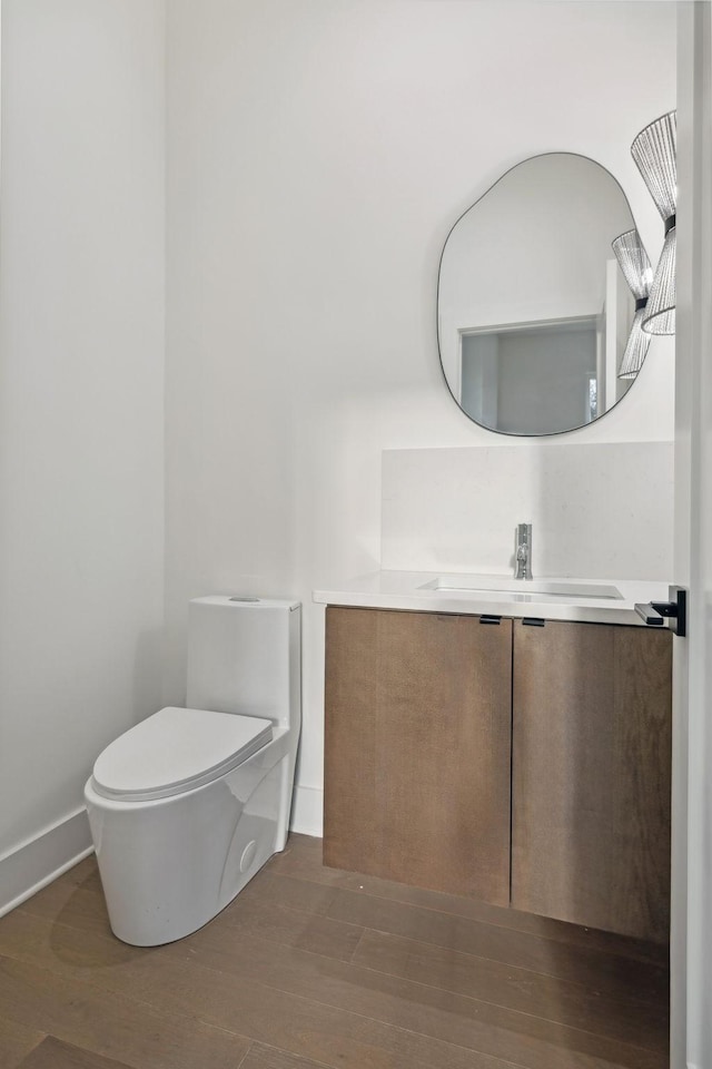 bathroom featuring vanity, hardwood / wood-style flooring, and toilet