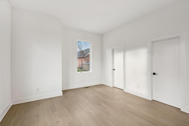 empty room with light hardwood / wood-style flooring