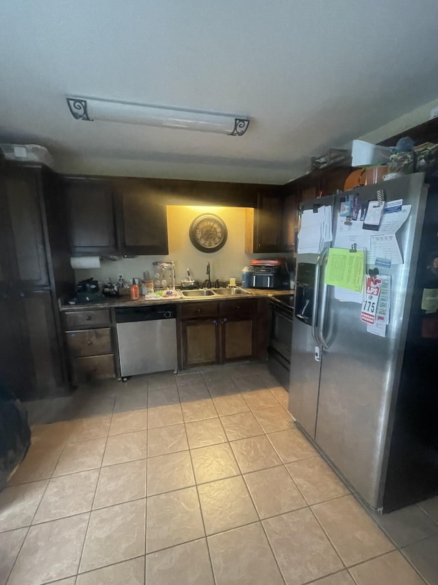 kitchen featuring light tile patterned floors, stainless steel appliances, dark brown cabinets, and sink