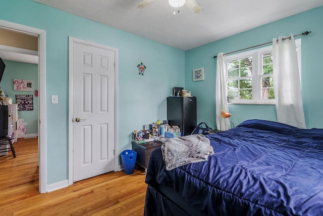 bedroom featuring hardwood / wood-style floors, a textured ceiling, and ceiling fan