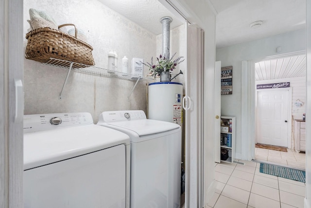 washroom featuring washing machine and dryer, gas water heater, and light tile patterned flooring