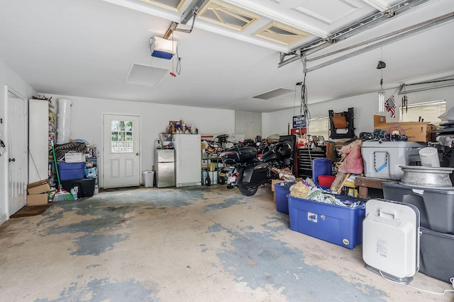 garage featuring stainless steel fridge and a garage door opener