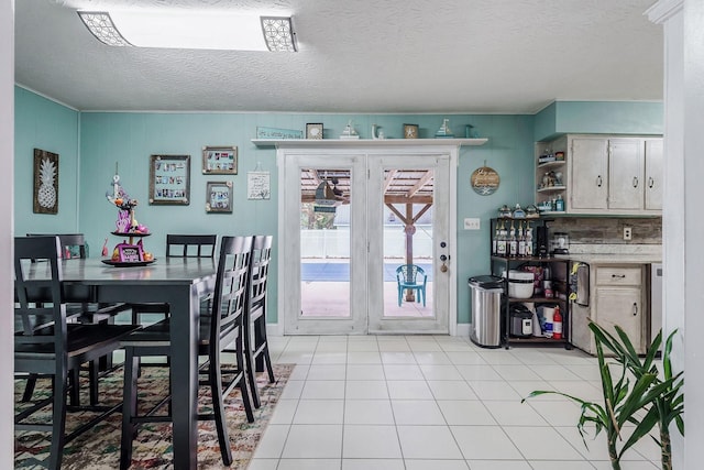 tiled dining area featuring a textured ceiling