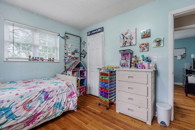 bedroom with wood-type flooring and a textured ceiling