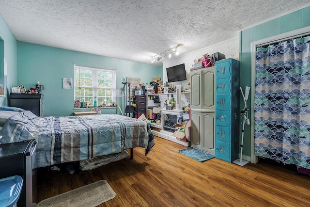 bedroom with hardwood / wood-style floors and a textured ceiling