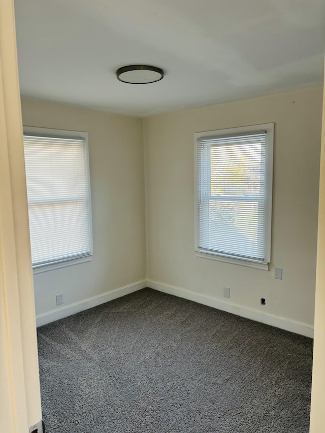 unfurnished room with dark colored carpet